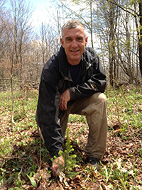 Dave Saville planting a spruce sapling.